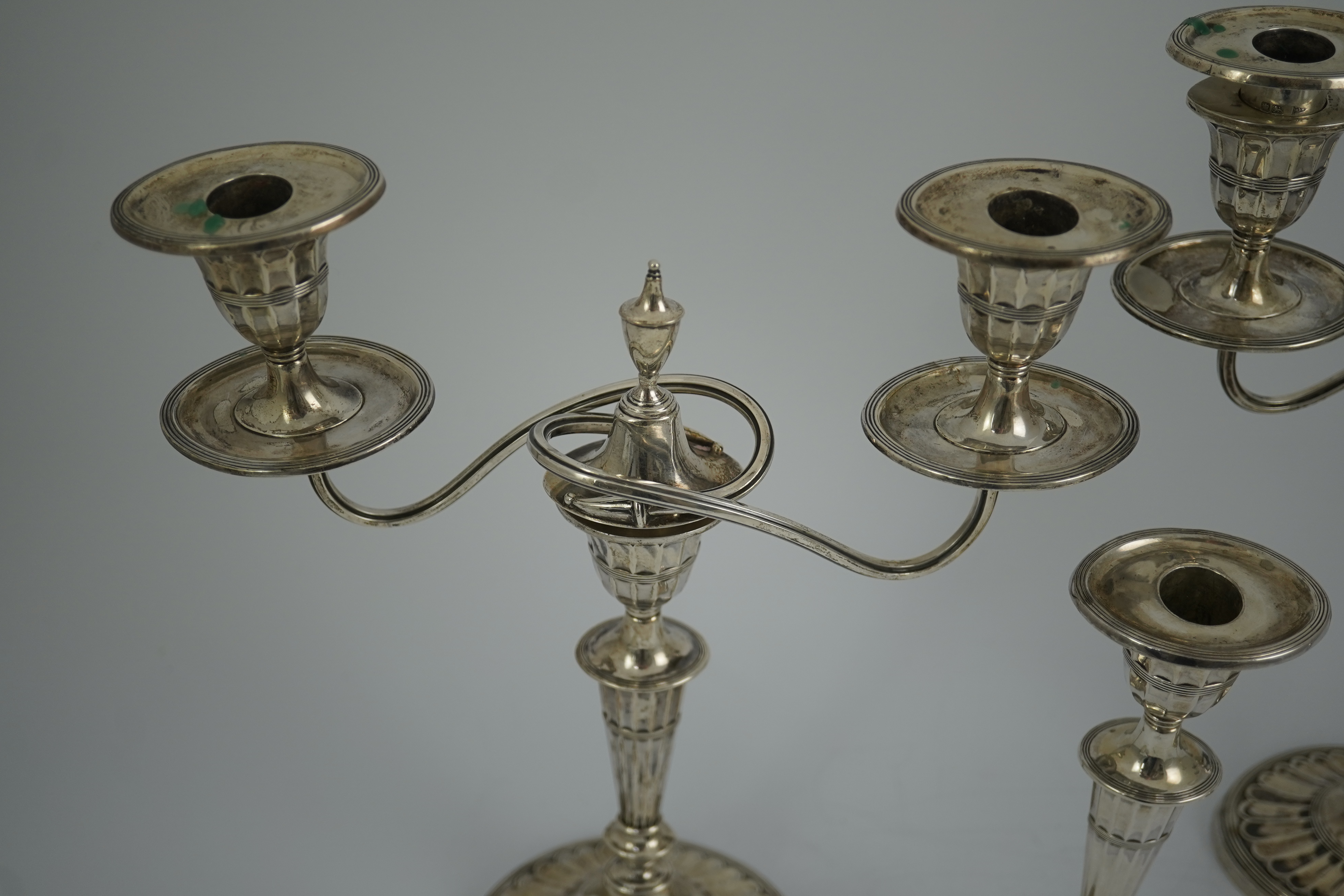 A pair of Edwardian silver two branch, two light candelabra, by Walker & Hall and a pair of matching candlesticks